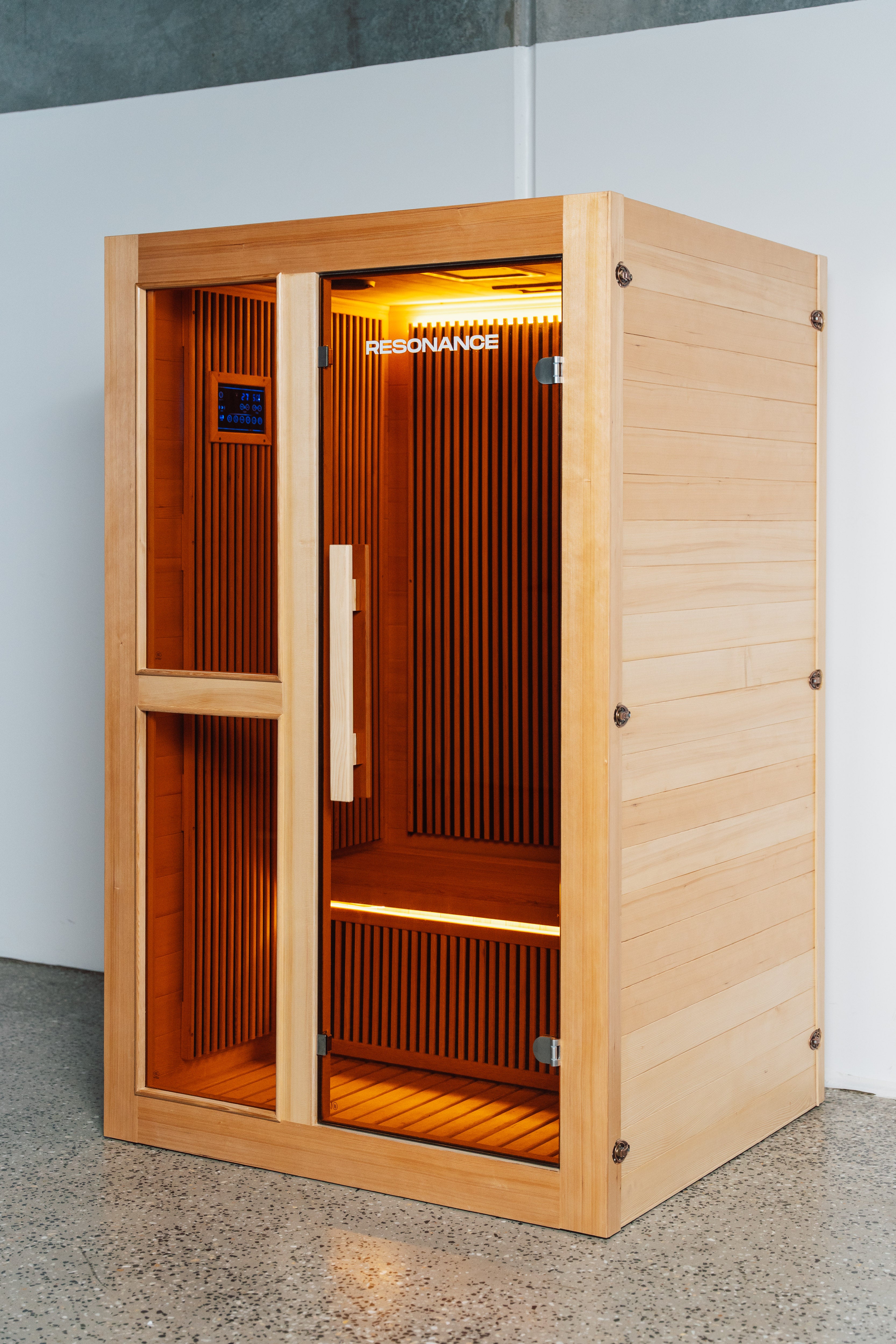 Recovery Pod 3/4 angle view — door open showing 2-person infrared sauna interior benches and digital control panel
